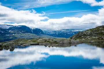 Fototapeta na wymiar Amazing reflection over a lake in the mountains of Trolltunga hike, Norway