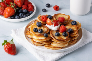 Homemade mini pancakes with blueberries, strawberries and raspberries