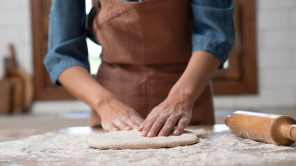 Woman hands kneading dough in the kitchen