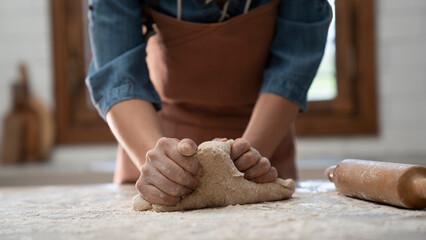 Woman hands kneading dough in the kitchen
