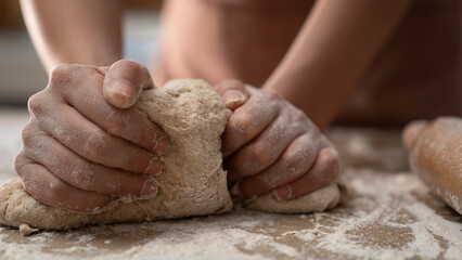 Woman hands kneading dough in the kitchen