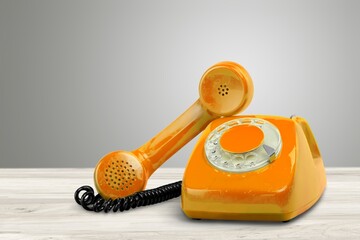 A retro colored old telephone on a table.