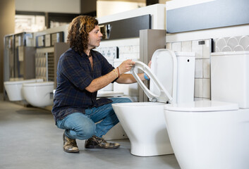 Confident man picking out new toilet in hardware store