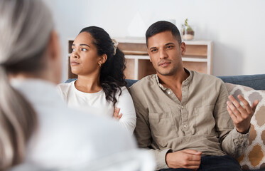 There he goes with the lies again. Shot of a young couple sitting together and looking annoyed during a consultation with a psychologist.