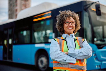 Proud female bus driver at station looking away. - obrazy, fototapety, plakaty