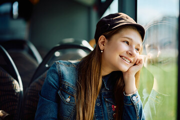 Happy little girl daydreaming while riding in bus. - obrazy, fototapety, plakaty