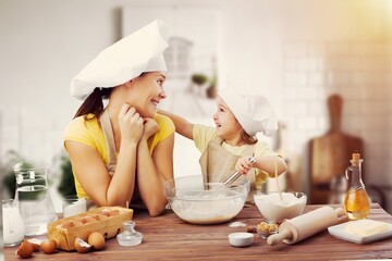 Happy young mother and child preparing a homemade dish