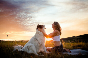 happy woman and dog enjoying sunset