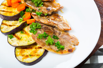 Tender slices of mutton chops served with grilled vegetables and parsley on plate