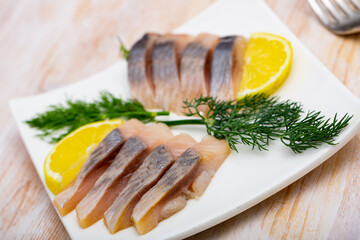 Mediterranean herring fillet served with sliced lemon and dill