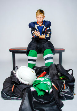 Male youth hockey player getting dressed before a game