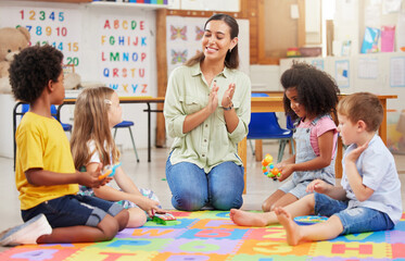 If you happy and you know it, clap your hands. Shot of a teacher singing with her preschool children.