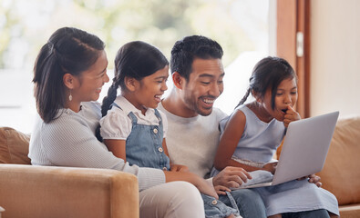 Theyre a family that stays connected. Cropped shot of an affectionate young family of four using a laptop while sitting on the sofa at home.