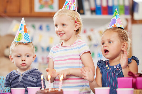 Parties make children feel extra special. Shot of a preschool children celebrating a birthday in class.