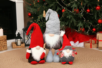 Obraz premium Cute decorative gnomes on floor near Christmas tree at home