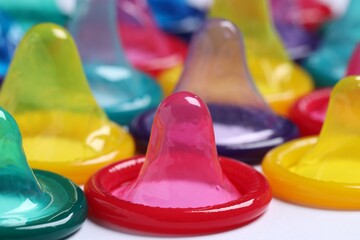 Colorful condoms on white background, closeup view. Safe sex