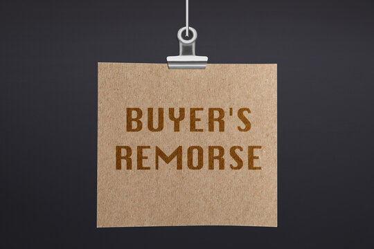 Text Buyer's Remorse on hanging poster against dark grey wall