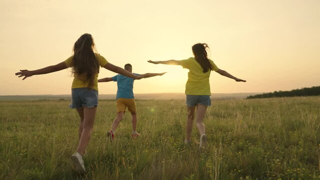 Happy Teenager. Children run together in park, sunset. Child boy, girl run. Friends dream of flying on an airplane, to be pilots. People in park, holiday running. Happy teenagers playing. Happy family