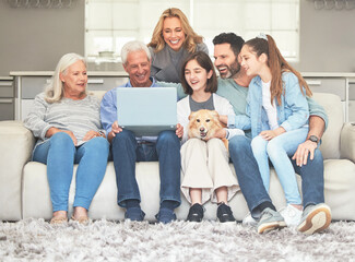 Never a dull moment when were together. Shot of a family using a laptop while sitting on a sofa...