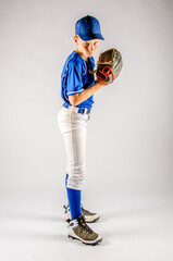 Youth male baseball player with ball in glove ready to pitch