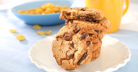 cookies with milk on a blue background. american chocolate chip cookie closeup. pastries on the table. sweets on a plate on a sunny day