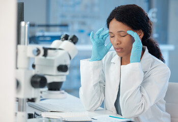 Theres no need for this. Shot of a young lab worker experiencing a headache while at work.