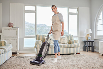 Once you clean your space, youll clear your mind. Portrait of a young woman vacuuming a carpet in...