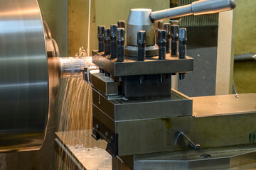 Close up scene the lathe machine finish cut  metal shaft parts with liquid coolant method.