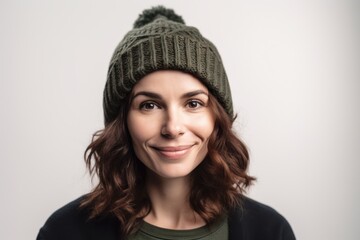 Medium shot portrait photography of a grinning woman in her 30s wearing a warm beanie or knit hat against a white background. Generative AI