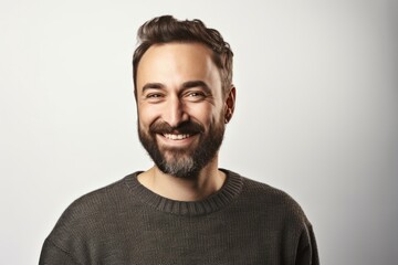 Portrait of a handsome bearded man smiling at the camera over white background