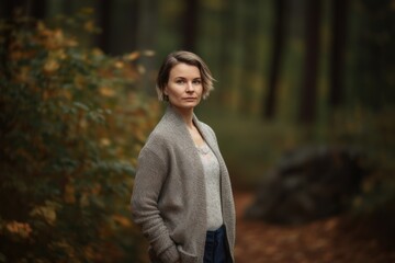 Fototapeta premium Portrait of a beautiful young woman in the autumn forest. Autumn fashion.