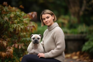 Beautiful young woman with her dog in the park on an autumn day