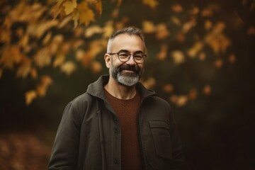 Obraz premium Handsome middle-aged man with a beard and glasses in a park in autumn