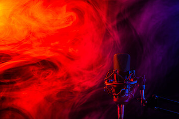 Fototapeta na wymiar Professional microphone in red blue smoke on a black background.
