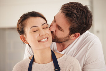 You make me feel loved. Shot of a man kissing his wife on her cheek at home.