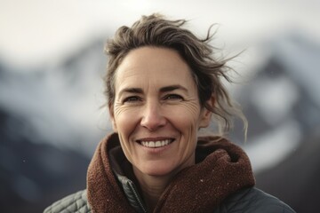 Portrait of a smiling middle-aged woman in the mountains.
