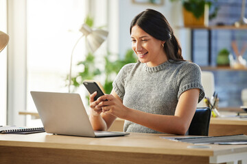 Keeping track of her affairs. Shot of a young businesswoman using her smartphone to send a text...