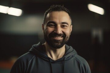 Portrait of a handsome bearded man smiling at camera in a gym