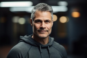Obraz premium Lifestyle portrait photography of a pleased man in his 40s wearing a cozy sweater against a gym or fitness center background. Generative AI