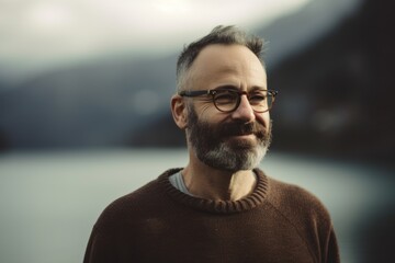 Fototapeta premium Portrait of a bearded man with glasses on a background of mountains