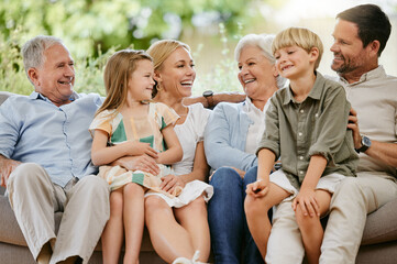 Happy and smiling multi generation caucasian family sitting close together on the sofa at home....