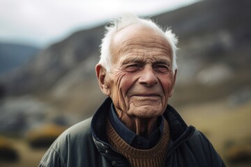 Portrait of an elderly man in the mountains. Selective focus.