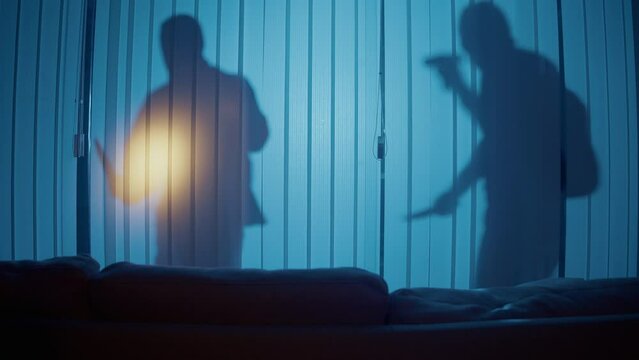 Silhouette of Two Criminals Near Window at Night Holding a Knife and Crowbar. Smart Home Security.Protecting Your Home from Burglary. Security Inside the House. Access Control System
