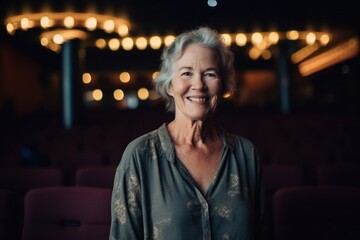 Obraz na płótnie Canvas Portrait of smiling senior woman sitting in cinema hall during movie night