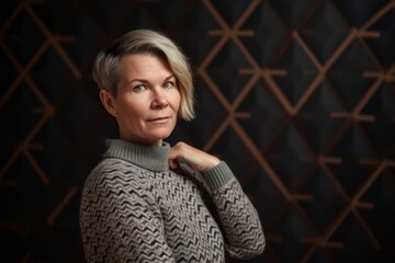 Portrait of a middle-aged woman in a sweater on a dark background