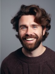 Fototapeta premium Portrait of a smiling young man in sweater, over grey background.