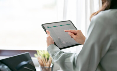Closeup shot of woman hand using digital tablet. Young businesswoman analyzing weekly schedule on her tablet sitting at office.