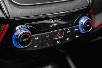 Modern black car interior: climat control view with air conditioning button, the dashboard with information about temperature inside a car