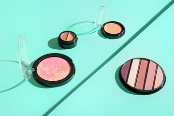 Eyeshadows, blush and concealers on color background