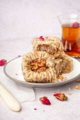 Plate of tasty baklava on light background